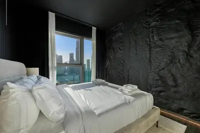 a bedroom with a large bed with a window at Burj Khalifa Views Pool, Gym & Downtown Ease in Dubai