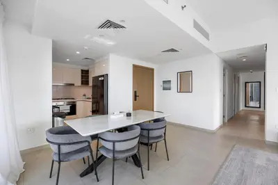 a kitchen and dining room with a table and stools at Burj Khalifa Views Pool, Gym & Downtown Ease in Dubai