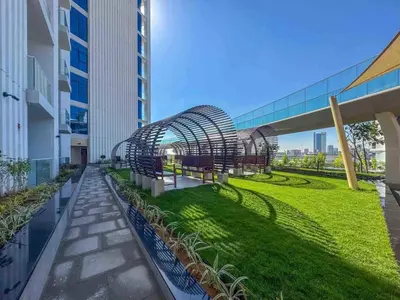a walkway with benches and grass on a building at 21 Studio in Skyz by Danube, Arjan in Dubai