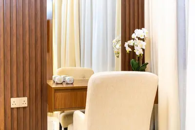 a room with two chairs and a table with flowers at Modern 2BR Prime Downtown Location in Dubai