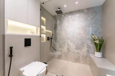 a bathroom with a toilet and a glass shower at Modern 2BR Prime Downtown Location in Dubai