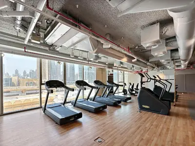 a gym with a row of treadmills at Chic & Classic 1BDR In Downtown Views-14 in Dubai