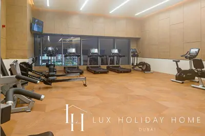 a gym with several treadmills and exercise machines at LUX Iconic Views at The Palm Tower Suite 8 in Dubai
