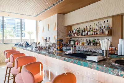 a bar in a restaurant with orange bar stools at LUX Iconic Views at The Palm Tower Suite 8 in Dubai