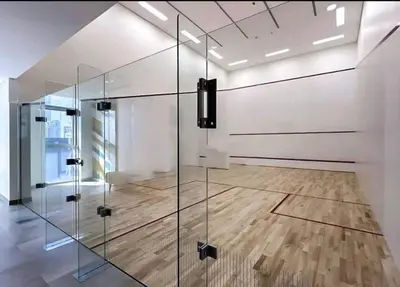 a glass partition in a room with a wooden floor at have fun with your family and friends in our apt in Dubai
