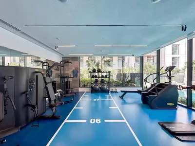 a gym with blue flooring and tread machines at PVH - Kensington Waters - Lavish 1BR - Park Front in Dubai