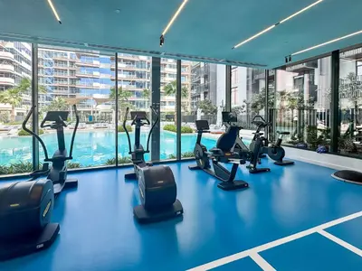 a gym with treadmills and ellipticals in a building at PVH - Kensington Waters - Lavish 1BR - Park Front in Dubai