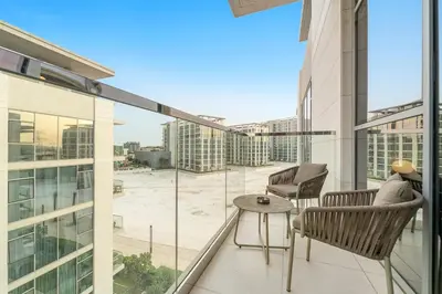 a balcony with chairs and a table on a building at FIRST CLASS 1BR Relaxing Urban Escape in Dubai
