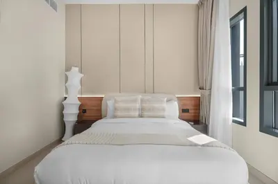 a white bed in a room with a window at Luxury 2BR w City View Balcony in Dubai