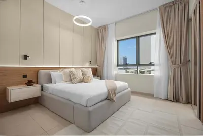 a bedroom with a bed and a large window at Luxury 2BR w City View Balcony in Dubai