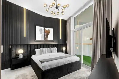 a bedroom with a large bed and a chandelier at Gogoto6 2BR Super Premium Canal & Burj Khalifa View in Dubai