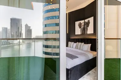 a bedroom with a bed and a view of a city at Gogoto6 2BR Super Premium Canal & Burj Khalifa View in Dubai