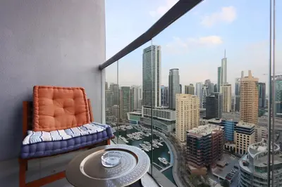 a room with a chair and a view of a city at Prime Located 3B with full Marina Views, Near Beach & Marina Mall in Dubai