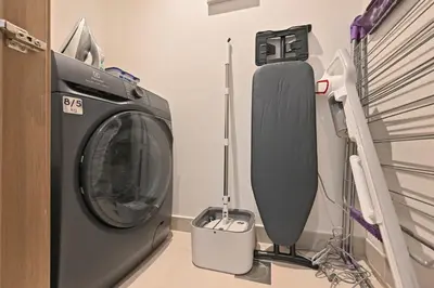 a washing machine and a tv in a room at Luxury 1BR Beach Access Creek Beach in Dubai