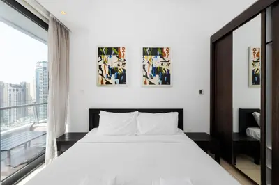 a bedroom with a white bed and a large window at Silverene Tower A, Dubai Marina - Mint Stay in Dubai