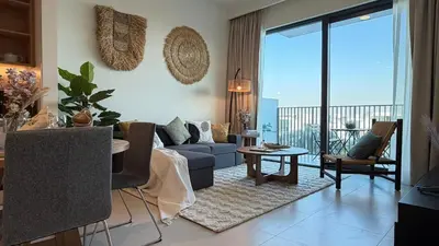 a living room with a couch and a table at Serene 1BDR in Dubai Hills with Balcony in Dubai