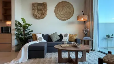 a living room with a blue couch and a table at Serene 1BDR in Dubai Hills with Balcony in Dubai