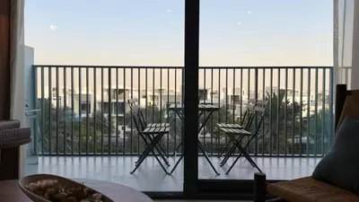a balcony with two chairs and a view of a city at Serene 1BDR in Dubai Hills with Balcony in Dubai