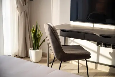 a desk with a chair next to a desk with a television at Stylish 1BR with Pool & Gym Access in Dubai