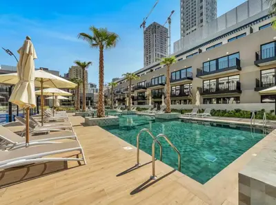 a swimming pool with chaise lounge chairs next to a building at Modern & Cozy JVC Studio Couple or Solo in Dubai
