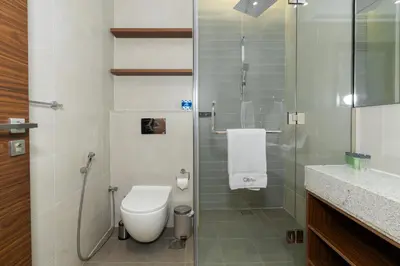 a bathroom with a toilet and a glass shower at CitiHome - Spacious 2BR - Park Gate Residences in Dubai