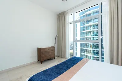 a bedroom with a bed and a large window at CitiHome - Spacious 2BR - Park Gate Residences in Dubai