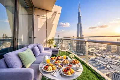 a table with plates of food on a balcony with a view at Luxurious Burj Vista Apartment with Burj Khalifa view in Downtown Dubai in Dubai