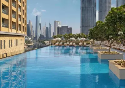 a large swimming pool with a city in the background at EMAAR Residences Fashion Avenue 1BHK by WS Holiday Homes in Dubai