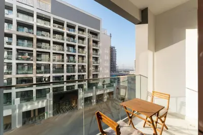 a balcony with a table and chairs and a building at Stylish City Studio with Balcony View in Meydan in Dubai