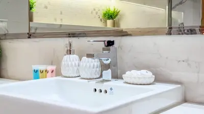 a bathroom sink with a faucet and a mirror at TRPS - Azizi RIviera 63, Al Meydan - Brand New Studio, Modern Furnished, Excellent Amenities in Dubai