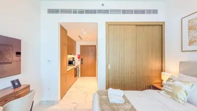 a hotel room with a bed and a kitchen at TRPS - Azizi RIviera 63, Al Meydan - Brand New Studio, Modern Furnished, Excellent Amenities in Dubai
