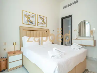 a bedroom with a large white bed with towels on it at Stylish 2BR Apartment Skyz By Danube Arjan in Dubai