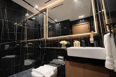 a bathroom with a sink and a toilet and a mirror at Luxury 2BR W Private Pool Binghattti Onyx in Dubai