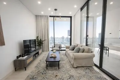 a living room with a couch and a tv at Luxury 2BR W Private Pool Binghattti Onyx in Dubai