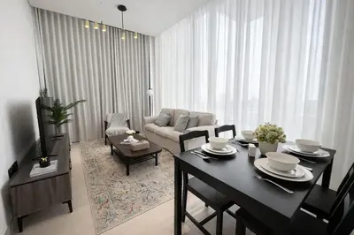 a living room with a table and a couch at Luxury 2BR W Private Pool Binghattti Onyx in Dubai