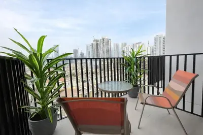 a balcony with chairs and a table and plants at Premium Studio W Pool & Gym Binghatti Aurora in Dubai