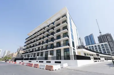 a large white building in the middle of a city at Premium Studio W Pool & Gym Binghatti Aurora in Dubai