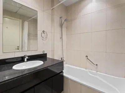a bathroom with a sink and a mirror and a tub at Exquisite Lavish Studio in Ghalia JVC -16 in Dubai
