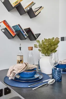 a table with plates and napkins and a bottle of wine at Frank Porter - Oxford Gardens in Dubai