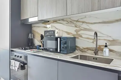 a kitchen with a microwave and a sink at Frank Porter - Oxford Gardens in Dubai