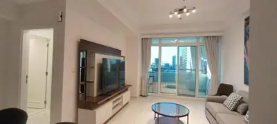 a living room with a couch and a television at Silk Valley - Luxury 1BR: Steps to Barasti Beach & Marina Walk in Dubai