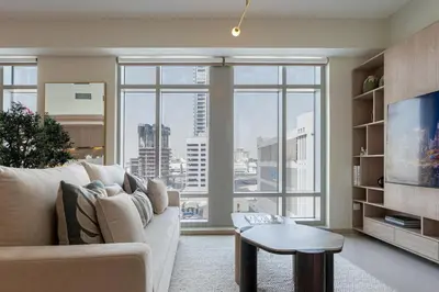 a living room with a couch and a large window at Stylish 1BDR Fully Upgraded Near Burj Khalifa in Dubai