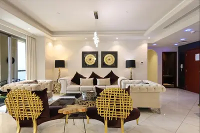 a living room with white furniture and a chandelier at Prime JBR 4B with Maid with Sea and Ain Dubai View in Dubai