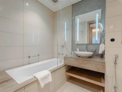 a bathroom with a tub and a sink and a mirror at Hollywood Glamour Epic Burj Views at DAMAC Towers by Paramount in Dubai