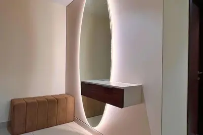 a bathroom with a mirror and a brown stool at Elegant 2BR Apartment with Huge Terrace, Dubai Land in Dubai