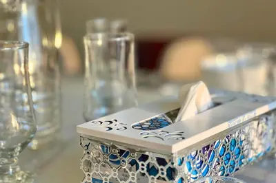 a table with glasses and a box on top of it at Elegant 2BR Apartment with Huge Terrace, Dubai Land in Dubai