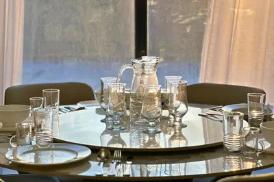 a table with glasses and a pitcher on top of it at Elegant 2BR Apartment with Huge Terrace, Dubai Land in Dubai