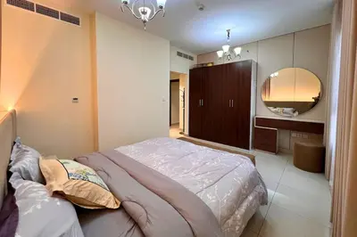 a bedroom with a large bed and a mirror at Elegant 2BR Apartment with Huge Terrace, Dubai Land in Dubai