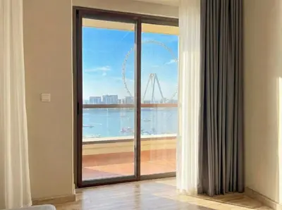 a room with a large window with a view of the wheel at Stunning Sea View - 2-BR - 2 min Walk to Beach in Dubai