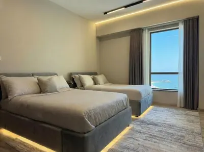 a hotel room with two beds and a couch at Stunning Sea View - 2-BR - 2 min Walk to Beach in Dubai